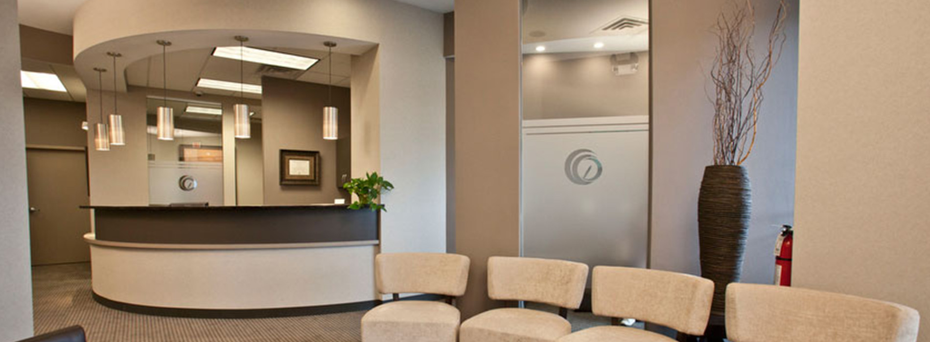 Waiting area in a modern office with a reception desk, seating, and decorative elements.